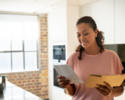 woman smiling opening direct mail in her home