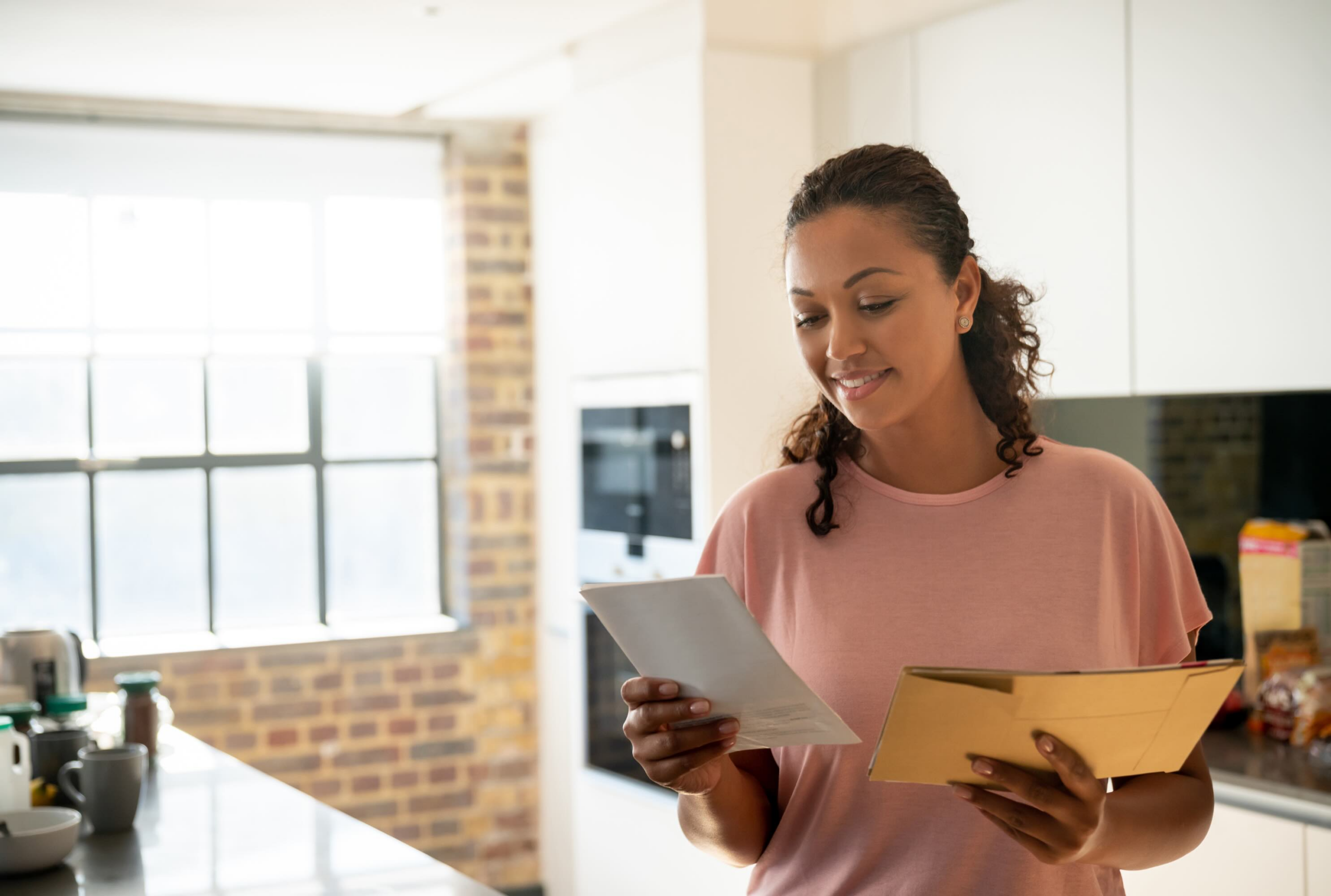 woman smiling opening direct mail in her home